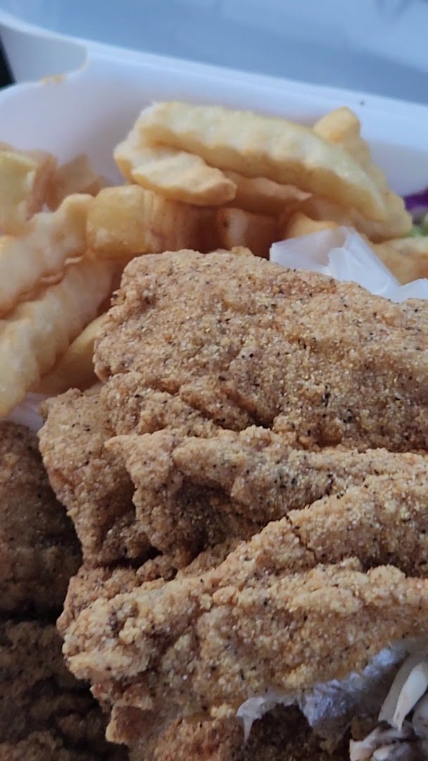 Catfish and sides served on white plates.